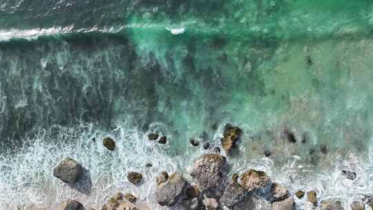 印尼巴厘岛清澈绿松石海水击打礁石溅起浪花