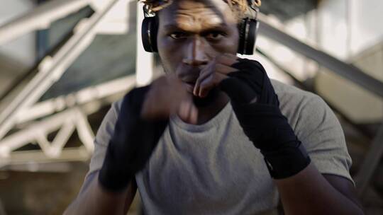 拳击手戴着耳机打拳的特写镜头视频素材模板下载