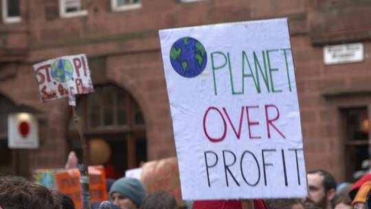 格拉斯哥气候变化抗议期间街头上的人手持抗议牌