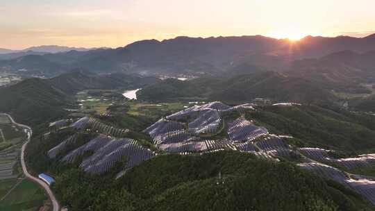 夕阳下山上的太阳能光伏发电站