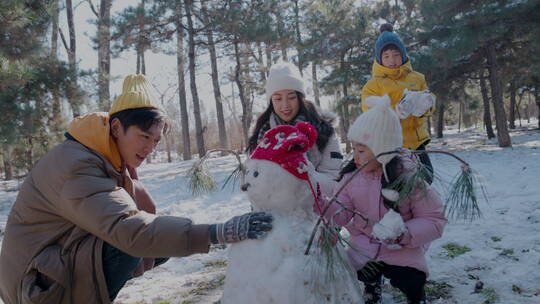 快乐家庭在雪地里堆雪人