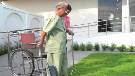 亚洲老年男性患者与护理人员一起做物理治疗视频素材模板下载