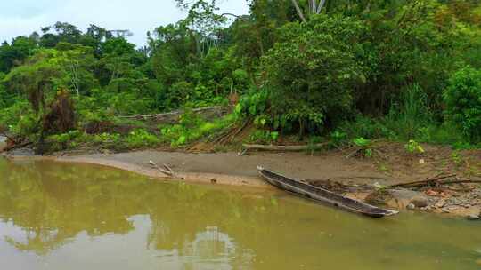木制独木舟躺在热带河流的沙洲上