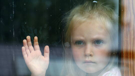 小女孩在窗前伤心