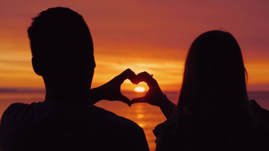 夕阳下情侣在海边牵手比心视频素材模板下载