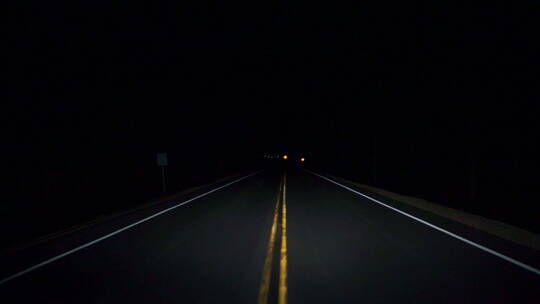 在夜色中行驶在蜿蜒曲折的黑暗乡村公路上