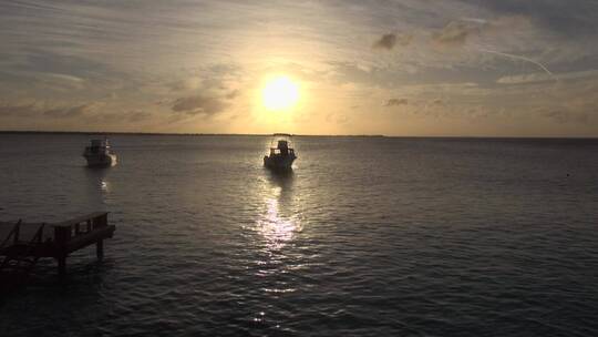 夕阳下的小船在海面慢慢游行