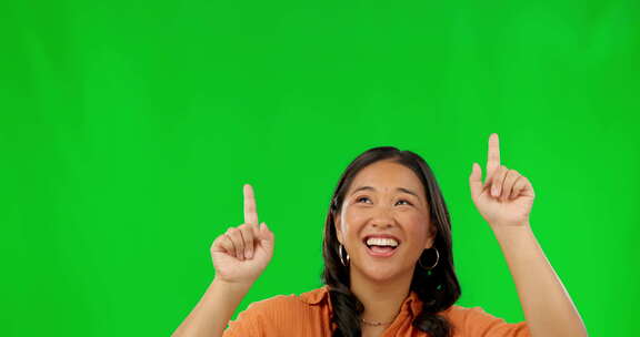 快乐的亚洲女人，在工作室背景下的绿屏上指