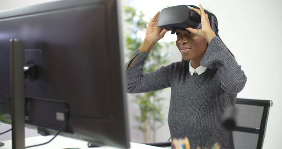 女人坐在电脑前感受VR技术