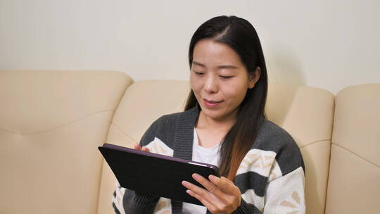 亚洲中国女性居家坐沙发办公玩手机上网购物