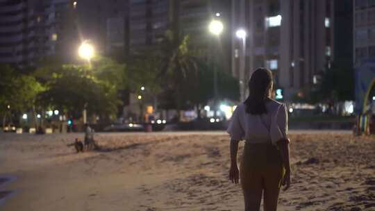 傍晚走在沙滩上的孤单女孩背影