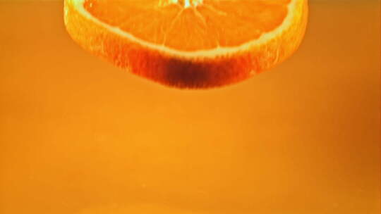 新鲜橙子碎片落入橙汁中溅起水花