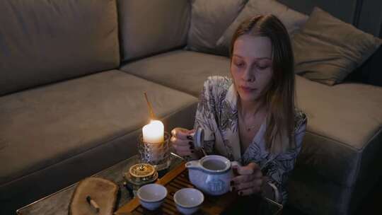 一个在杯子里倒茶的女人