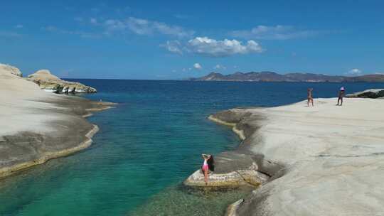 比基尼美女在海岛礁石晒日光浴希腊米洛斯岛