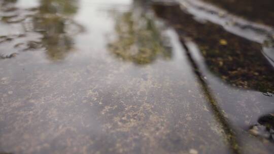 雨水落在路面水坑中的特写镜头