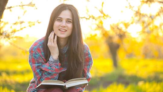 春天公园里看书的快乐女孩