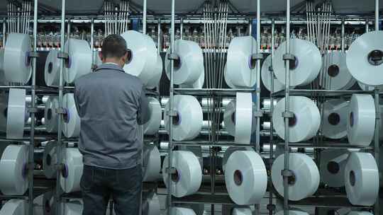 男性纺织工人在化纤纺织车间工作