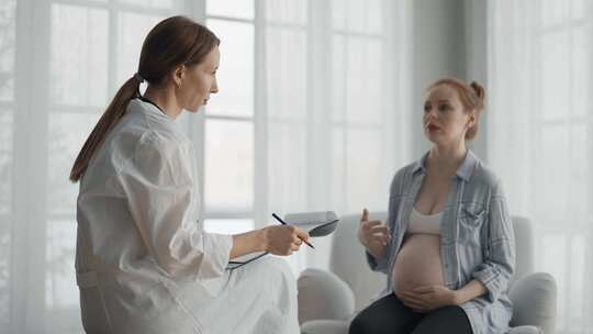 孕妇咨询医生兴奋的孕妇病人回答妇科医生