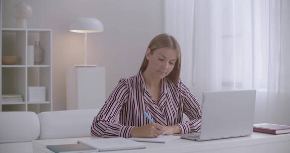 女人坐在电脑前记笔记