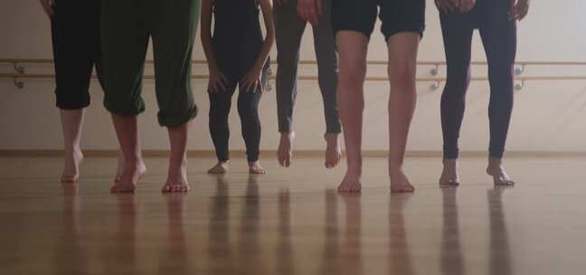 现代舞者在舞蹈室着陆时跳跃并拥抱膝盖