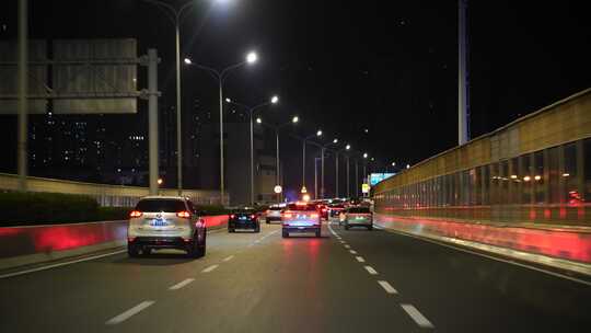 夜间开车行驶在城市道路夜晚城市车窗外风景