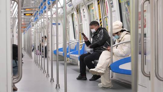 乘客在地铁车厢内使用手机
