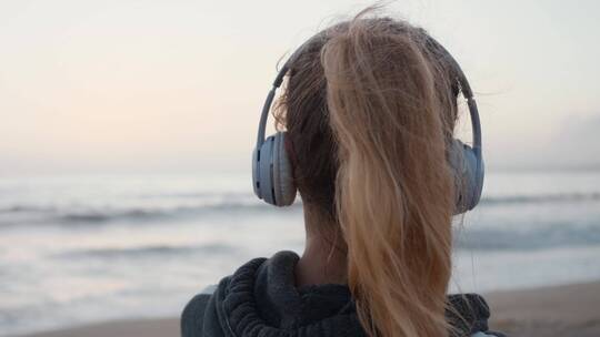 女孩在海边听着音乐