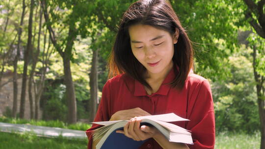 中国女性美女在公园树林看书学习