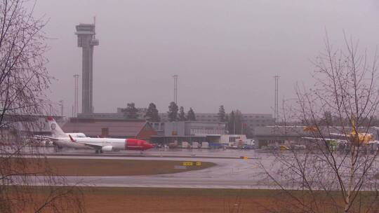 飞机在雨天的机场跑道上滑行