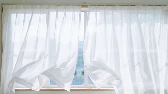 飘动的白色窗帘透过窗户