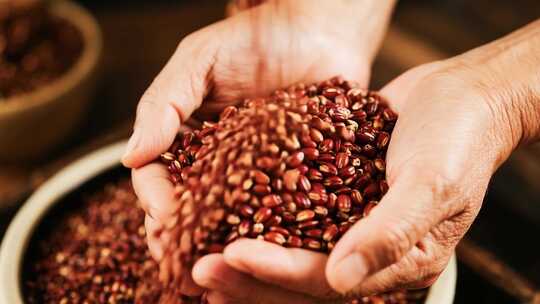 双手捧持红豆特写素材