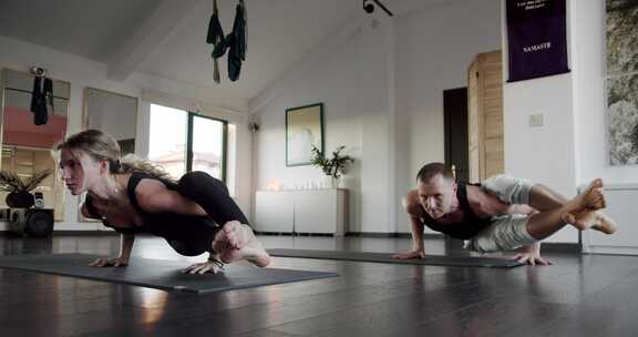 年轻的运动魅力人士与教练一起练习瑜伽课