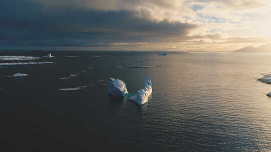南极洲上空日落时的雪山，正面空中跟踪视图