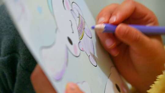 儿童拿着彩笔在绘本上涂画手特写视频素材模板下载