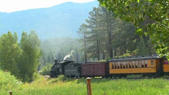 一列蒸汽火车穿过山脉的乡村视频素材模板下载
