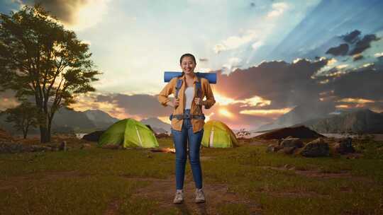 全身的亚洲女性徒步旅行者微笑到相机而帐篷