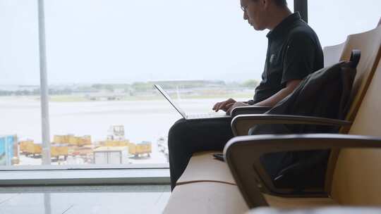 商务男子出差途中机场用笔记本电脑移动办公视频素材模板下载