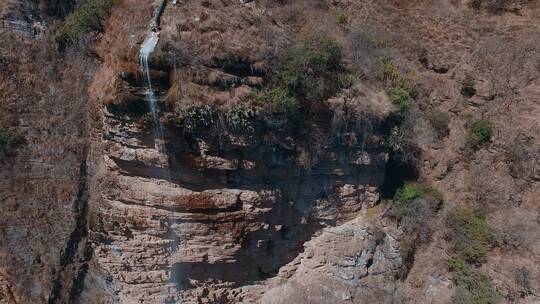 悬崖峭壁视频云南山区红砂岩石壁瀑布
