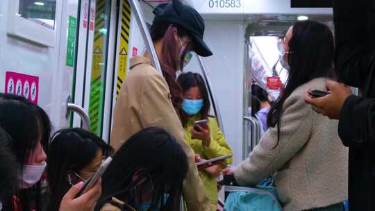 城市乘坐地铁玩手机的年轻人