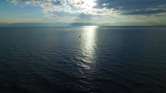 一叶扁舟在早晨波光粼粼的湖面