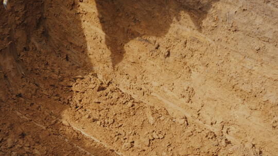 强大的挖掘机铲斗从施工现场的基坑中提取地面