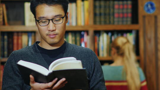 戴眼镜的男人在图书馆看书