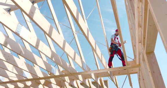 建筑工人在晴天为户外新结构建造木制框架