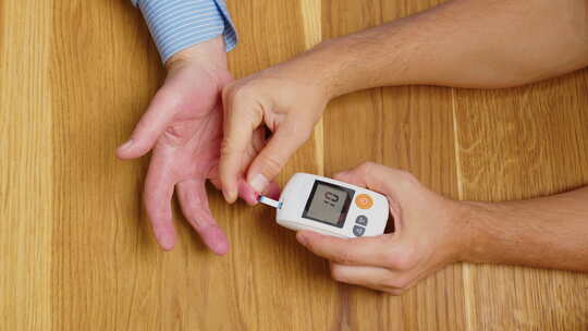 人手在桌上测量糖尿病的俯视图