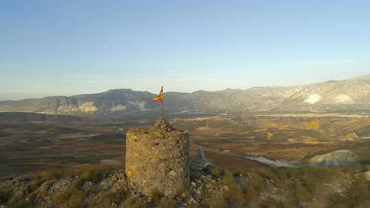举着西班牙国旗绕过废弃的旧瞭望塔