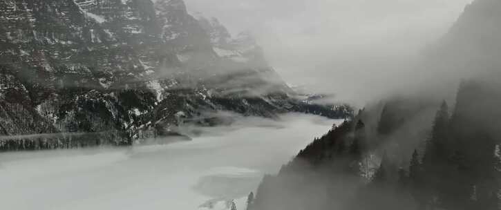 被雪覆盖的山峰之间云雾飘绕冰面寒流雾气