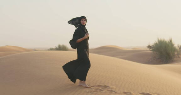 穆斯林女士在沙漠中行走