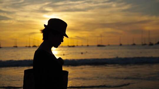 夕阳剪影视频夕阳下泰国海边的一个游客