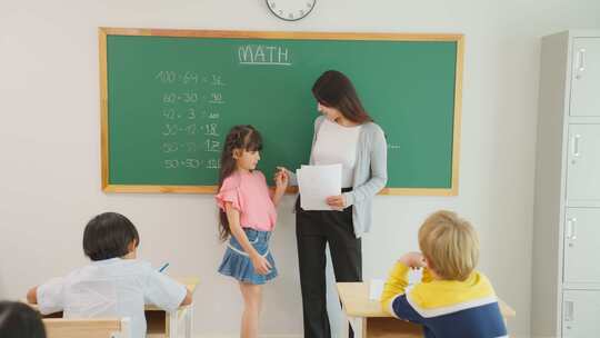 一群学生在小学教室里和老师一起学习。