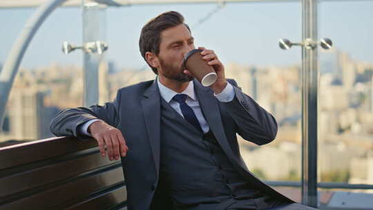 成功人士在玻璃露台上享受咖啡冷静的老板穿